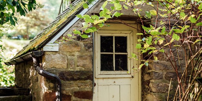 Up-close of an old stone building with a white door.